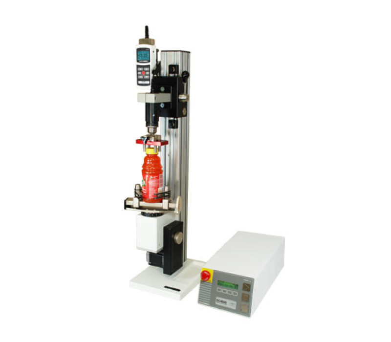 De TSTM-DC geavanceerde verticale gemotoriseerde koppeltestbank, getoond in een typische torsietest toepassing voor flessendoppen met 5i kracht-/koppelindicator, serie R50 koppelsensor en grepen.
