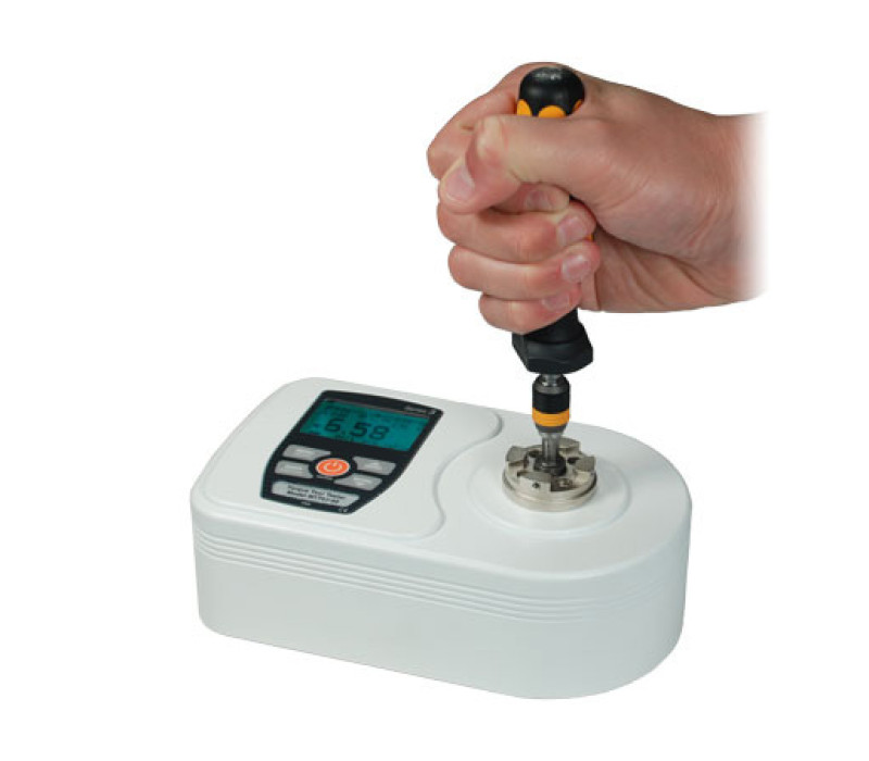 Om de TT02-torque-tester te bedienen, plaatst u eenvoudig het torque-gereedschap in de universele houder en draait u het. De uitlezing toont de real-time of maximale koppelwaarde met de klok mee of tegen de klok in. Hier afgebeeld met een handmatige momentschroevendraaier.