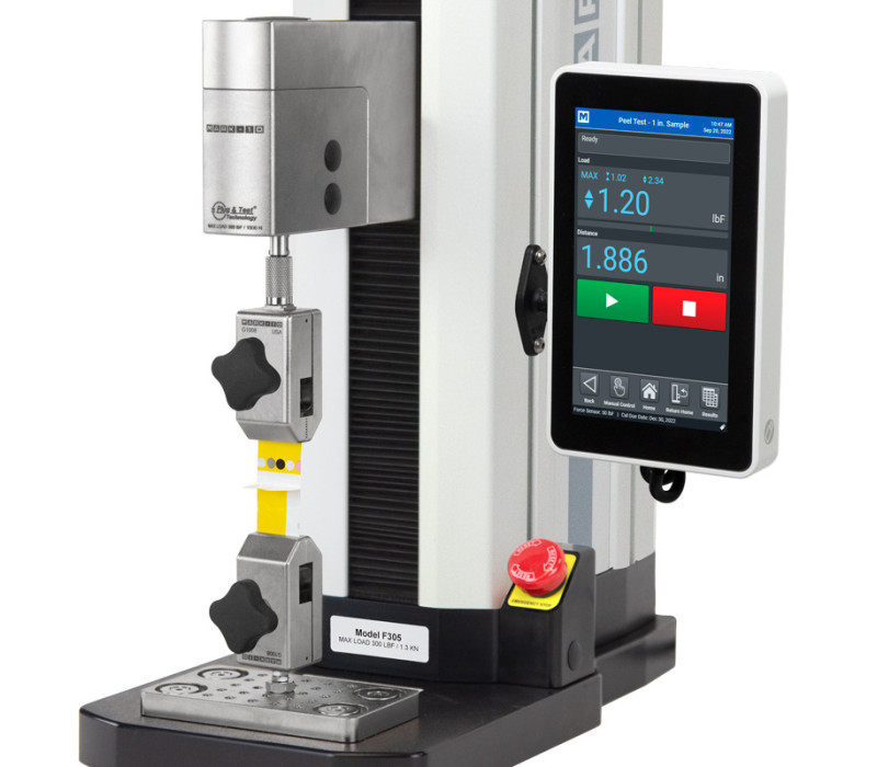 F305-EM-testframe met FS05 loadcel geconfigureerd voor een verticale afpeltest met twee G1008 film- en papiergrepen.